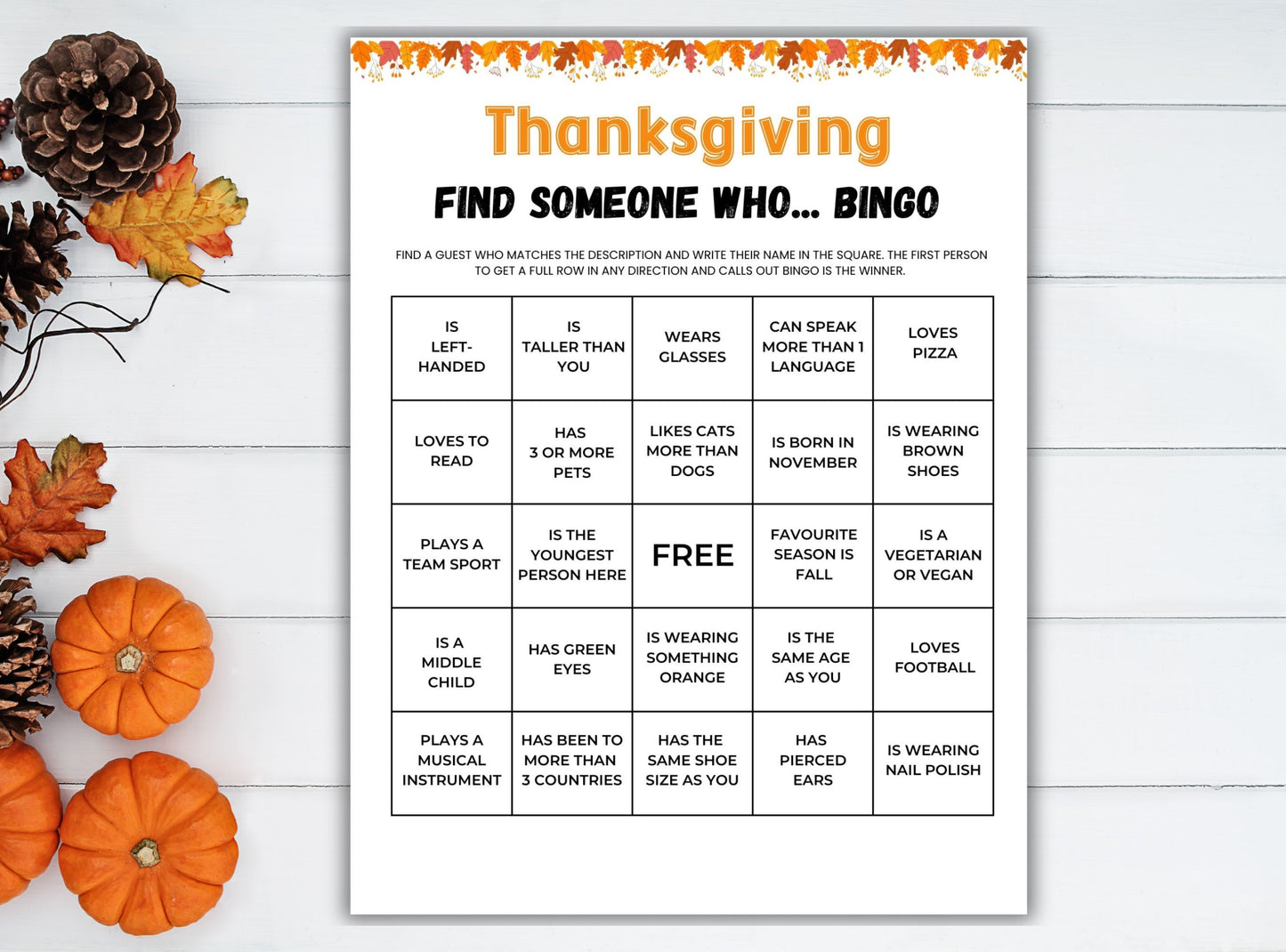 Thanksgiving 'Find Someone Who' bingo game on a white wooden surface with pumpkins and pinecones.