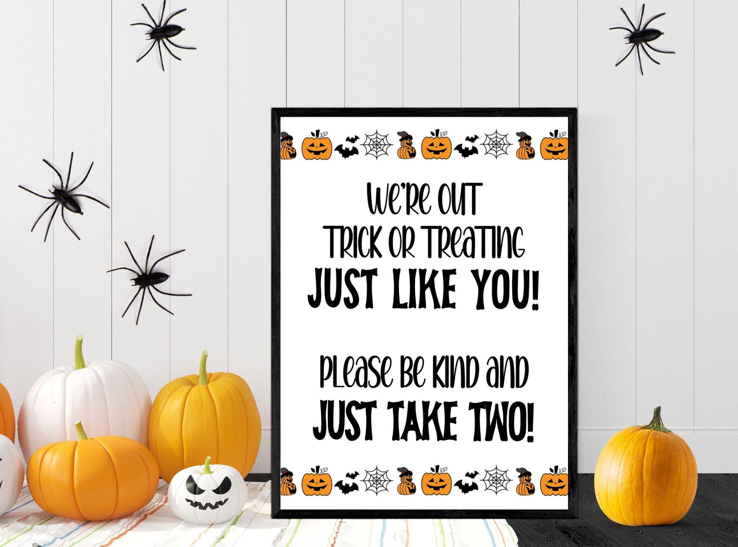 Halloween-themed sign with pumpkins and spiders on a wooden background