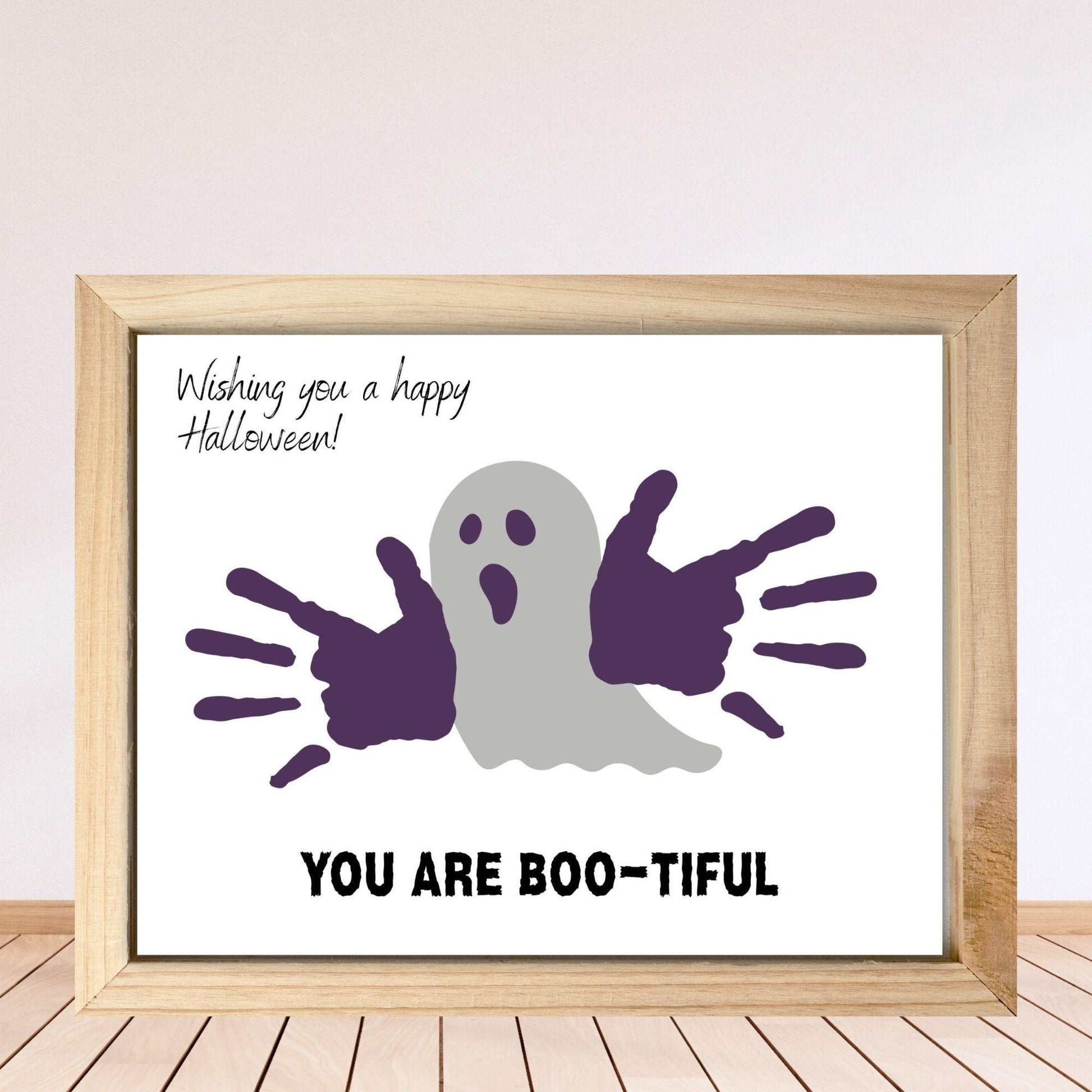 Framed Halloween-themed print with ghost and hand prints on a white background