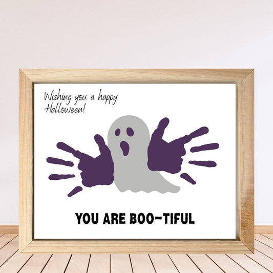 Framed Halloween-themed print with ghost and hand prints on a white background