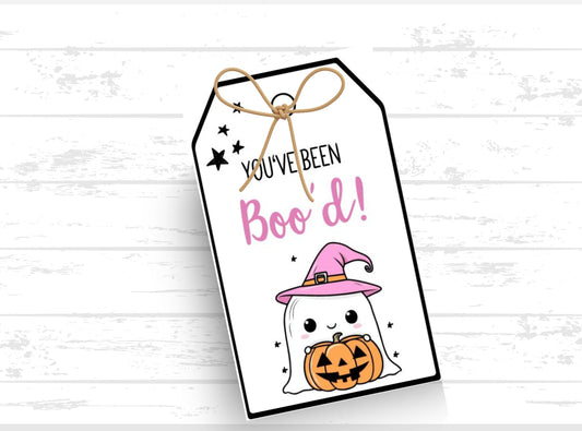 Halloween-themed gift tag with ghost, pumpkin, and text 'You've Been Boo'd!' on a white wooden background.